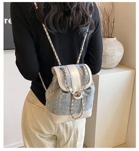 Detail of sequined denim mini backpack with cream leather trim and chain straps