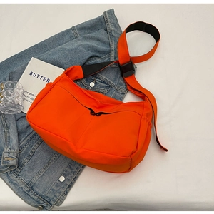 Détail d'une sacoche en nylon orange vif avec sangle réglable et boucle en plastique