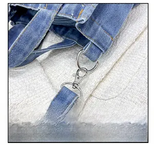 Detailed close-up of high-quality metal hardware and stitching on blue denim handbag