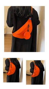 Detail view of orange canvas crossbody bag with small round coin pouch and adjustable strap