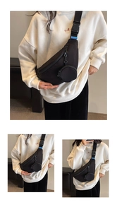 Detail of black nylon chest bag showing brand strap buckle and round coin pouch attachment
