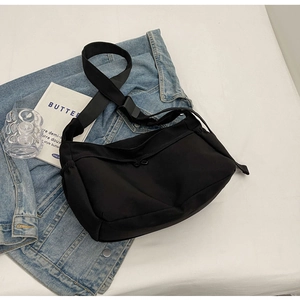 Détail du sac hobo en nylon noir avec bandoulière réglable et cordon de serrage