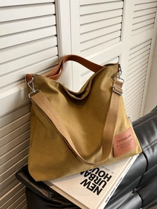 Minimalist large canvas tote bag in mustard yellow with brown leather handles and strap