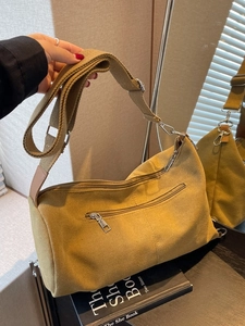 Mustard yellow canvas crossbody bag with wide shoulder strap and metal zipper