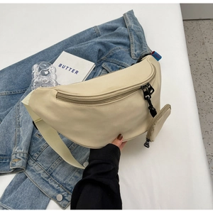 Detail of minimalist beige canvas crossbody bag with adjustable strap and small side pouch