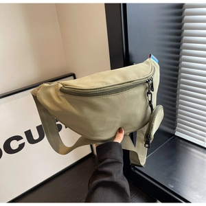 Detail of army green canvas chest bag with a detachable mini round coin purse and strap