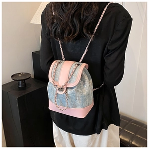Close-up of sequined bucket backpack with chain straps shown on person from behind