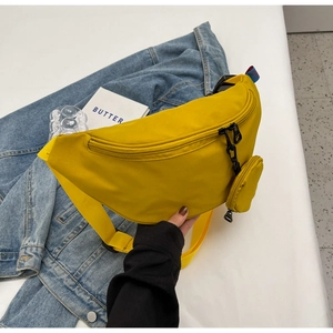 Detail of bright yellow nylon chest bag with mini round coin purse and wide strap
