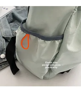Detail of mint green outdoor backpack with elastic side pocket and orange cord