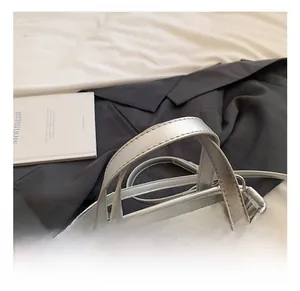Detail showing the quilted heart pattern and comfortable handles of the silver handbag