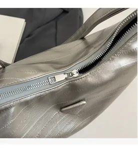 Detailed close-up of metallic silver tote bag with premium zipper and triangle plaque