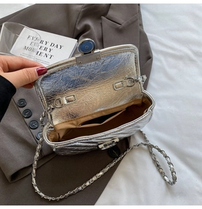 Interior detail of silver metallic flap bag with brown lining and chain strap