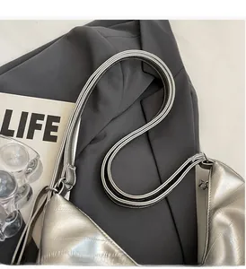 Close-up of double slim handles on a silver quilted tote bag with metallic texture