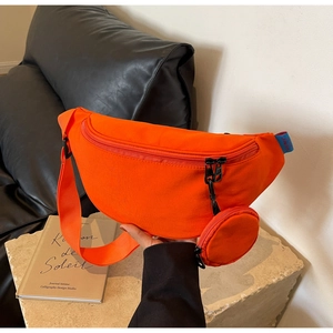 Orange canvas crossbody chest bag with adjustable strap and mini round pouch attachment
