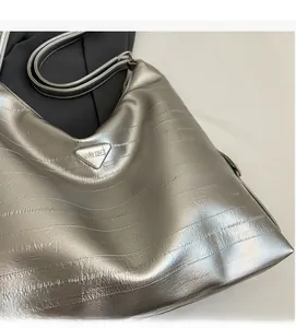 Detailed macro view of silver crinkled leather texture and triangular metal logo plate