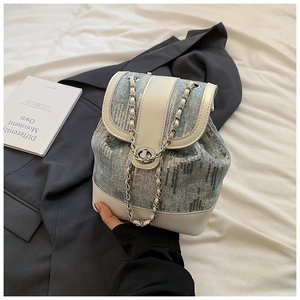 Detail of blue denim bucket bag with shiny silver sequins and metal chain strap