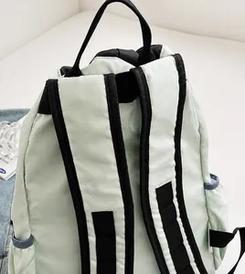Detail of mint green backpack featuring wide breathable black shoulder straps and waterproof nylon