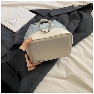 Detail of sequin denim bucket bag with beige leather base and silver chain handle