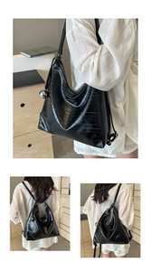 Detail of black glossy tote bag with embossed texture and silver metal ball charm