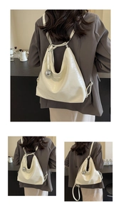 Close-up of cream crocodile pattern leather with silver metal ball charm on tote bag