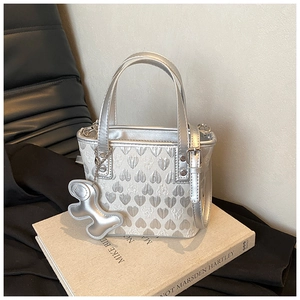 Close-up of silver mini heart-embossed tote bag with a cute metal bear charm