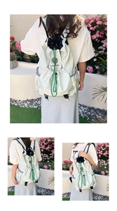 Detail of light green drawstring backpack featuring Tennis Boy Club logo and side pocket