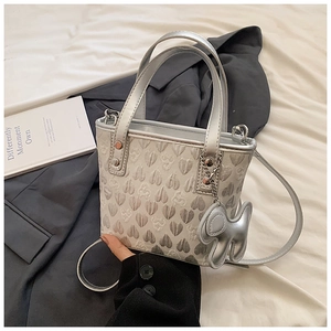 Detail view of silver heart-pattern jacquard bag with a cute puppy-shaped charm
