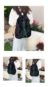 Detail of lightweight black drawstring backpack with green cords and tennis club print