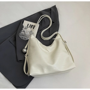 Detail of ivory hobo bag featuring premium embossed texture and adjustable shoulder strap