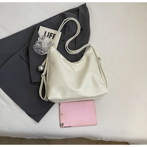 Detail of cream white textured hobo bag showing large capacity for tablet and items