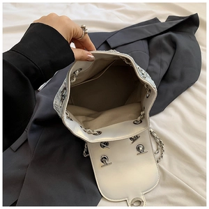 Detail of the silver glitter bucket bag interior with light gray lining and inner pocket