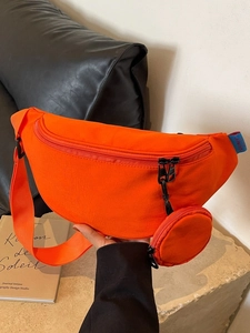 Orange half-moon canvas crossbody bag with a round mini pouch shown in hand