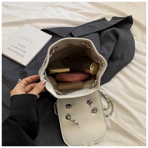 Detail view of the white bucket bag interior showing spacious lining and metal chain