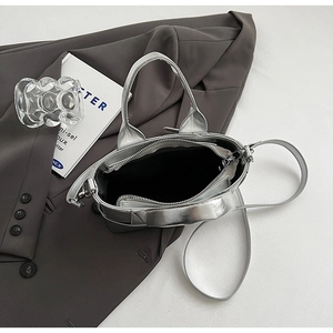 Top view of silver bucket bag showing zipper closure and black interior lining details