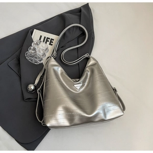 Detail of silver metallic hobo bag featuring horizontal texture and triangle logo plate