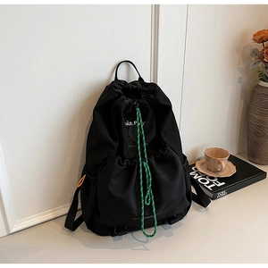 Detail of black nylon outdoor backpack with Fair Play print and green drawstring cord