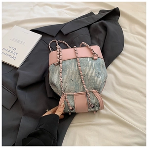 Detail view of pink PU leather bucket bag with blue wave sequins and silver chain straps