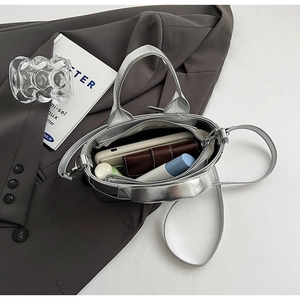 Detail view of silver metallic leather bucket bag interior holding a phone and wallet