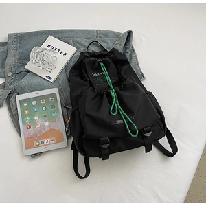 Detail of black nylon drawstring backpack with green tennis print and flap buckle closure