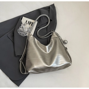 Silver metallic hobo bag with horizontal texture and a decorative spherical pendant charm