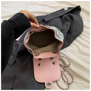 Detailed internal view of pink and blue bucket bag with leather texture and chain strap