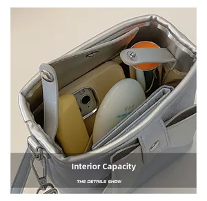 Spacious interior of silver metallic bucket bag showing storage for phone and makeup