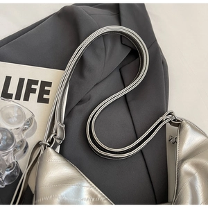 Detail of silver quilted tote bag featuring multi-strand thin shoulder straps and metallic finish