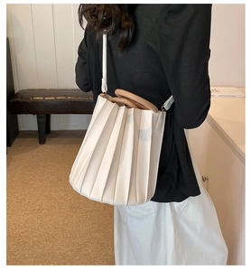 Sac seau plissé blanc avec poignée en bois et bandoulière porté par un mannequin
