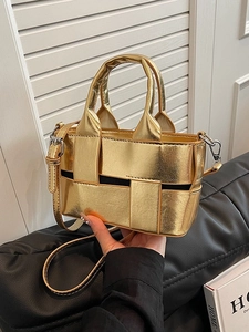 Metallic gold woven bucket bag with double handles and adjustable crossbody shoulder strap