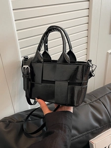 Elegant black woven mini bucket bag in glossy leather with adjustable shoulder strap