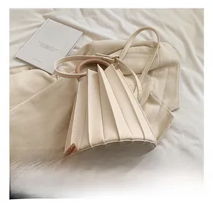 Détail du sac seau plissé crème avec poignée en bois et texture élégante en simili cuir