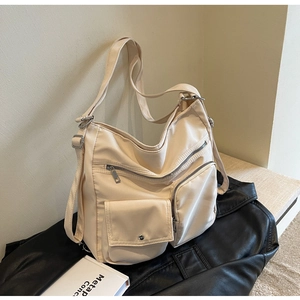 Detailed view of the multi-pocket nylon bag featuring secure zippers and adjustable strap