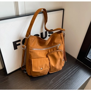 Detail of caramel nylon bag featuring waterproof fabric and multiple functional zip pockets