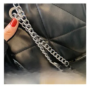 Detailed view of silver thick chain hardware on black quilted leather underarm bag